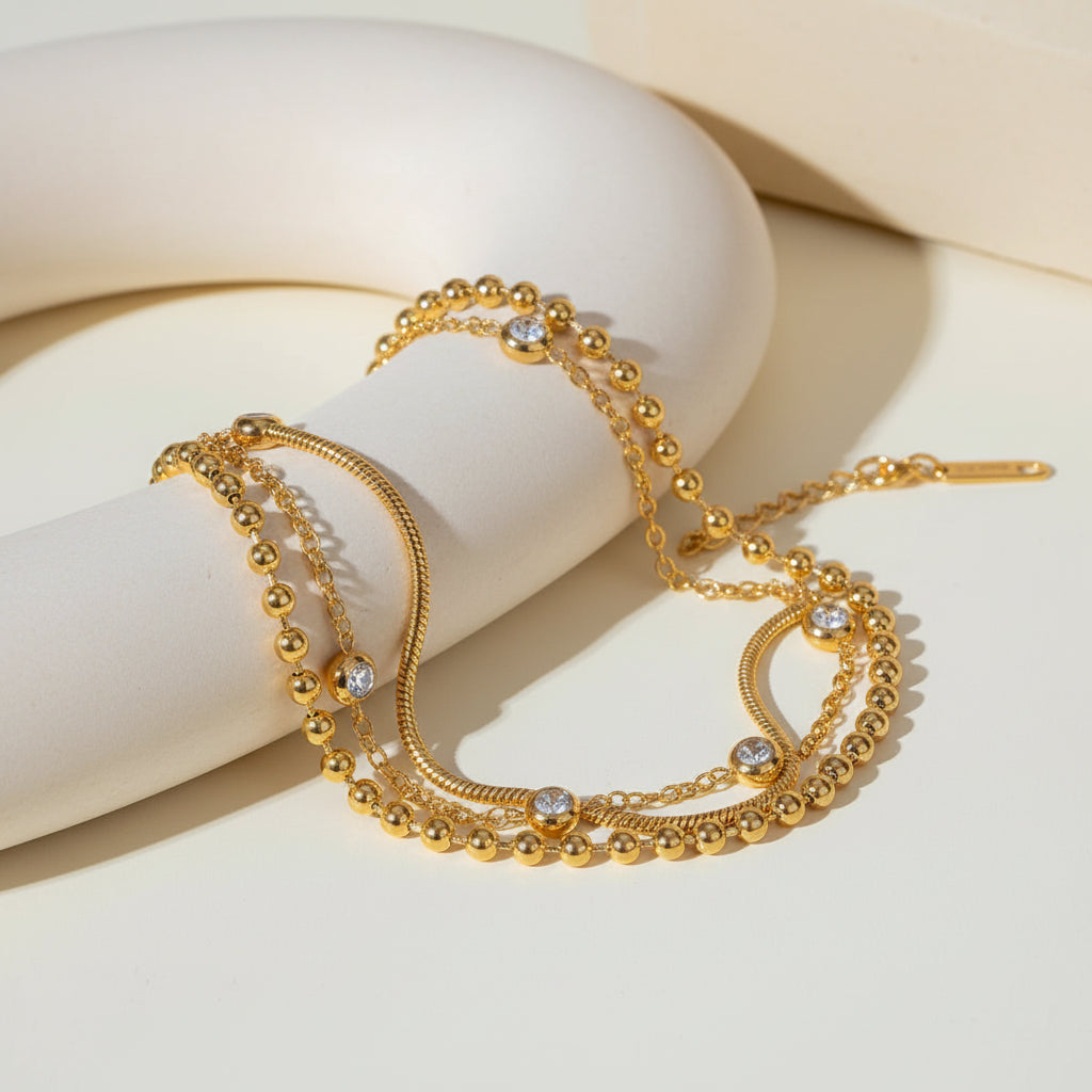Gold necklace with beads and crystals on a light background