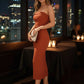 After Dark Strapless Midi Dress in rust ribbed fabric with side slit, worn in a nighttime restaurant setting.