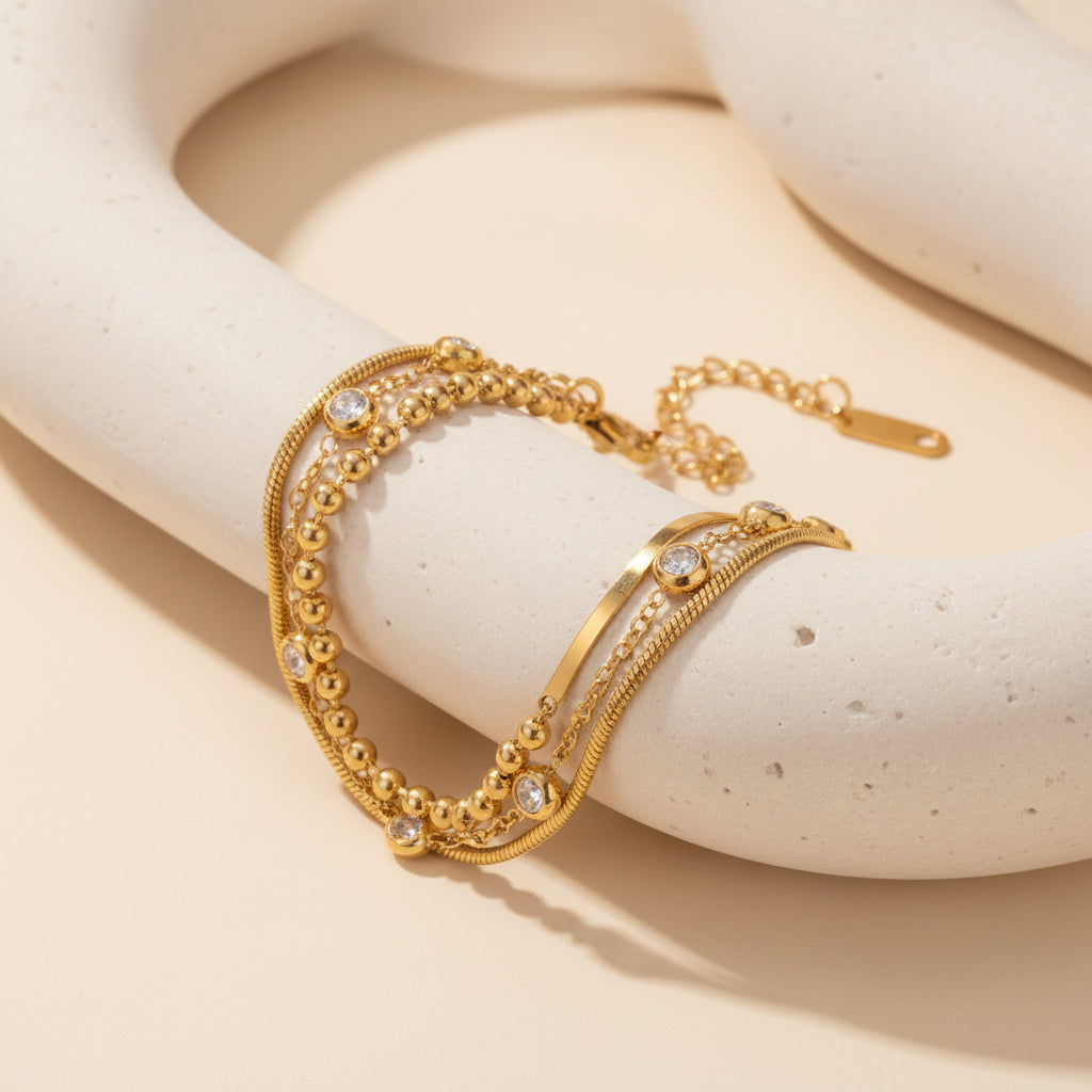 Gold bracelet with multiple layers on a white background
