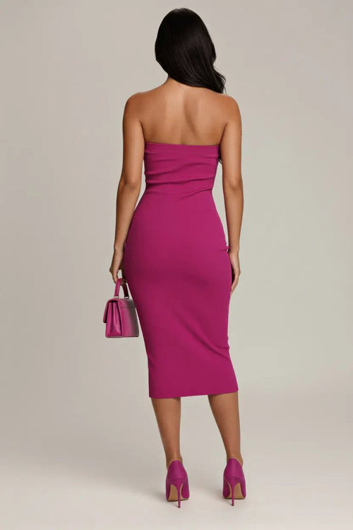 Main Character Strapless Midi Dress in magenta on model, back view with body-con silhouette, pink handbag and heels.