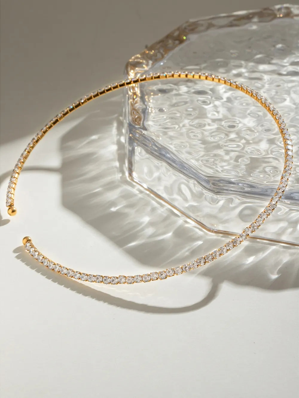 Gold headband with small stones on a textured surface